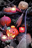 Halloween-Deko: Geschnitzte Kürbisse, Kerzen und Hexenbesen