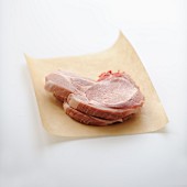 Raw pork chops on brown paper