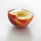 Halber weisser Pfirsich vor weißem Hintergrund