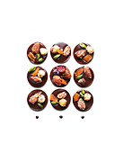 Komposition mit Schokoladen-Trockenfrüchte-Taler vor weißem Hintergrund