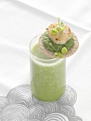 Green gazpacho with a cracker garnished with mashed peas and scallops