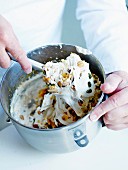 Mixing together the meringue, dried fruit, nuts and confit citrus with a rubber spatula
