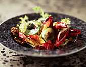 Salad of red chicory, frisée, cucumber and walnut kernels