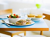 Gedeckter Mittagstisch mit Thunfischsteaks, Gemüsepfanne und Zitronentörtchen