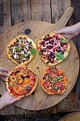 Verschiedene Pizzen auf Holzbrett