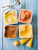 Assortment of punnets of ice cream, ice cream cones and ice cream scoop