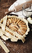 Covering the apple pie with strips of uncooked pastry