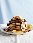 Pancakes mit karamellisierten Bananen, Schokoladensauce und Kokosraspeln