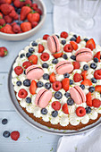 Pistachio and summer berry cake topped with mini Macarons
