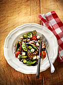 Grilled summer vegetables with diced cheese and basil