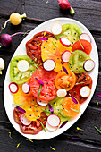 Tomato,radish,sesame seed and dandelion petal multicolored salad