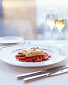 Fish fillet gratinated with cheese on tomato salad
