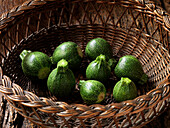 Wicker basket with round courgettes
