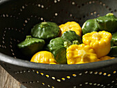 Yellow and green pâtissons in a sieve
