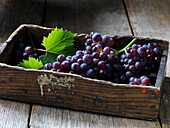 Wooden box with red grapes
