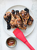 Gegrillte, angekohlte Hühnerkeulen mit Barbecue-Sauce