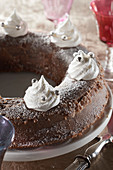 Flaumiger Schokoladenkuchen mit Kastaniencreme, mit Baisergebäck und Silberperlen verziert