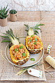 Pineapple halves garnished with rice and shrimp sauté