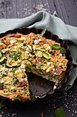 Sliced fromage frais and green vegetable quiche