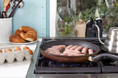 Raw sausages in a pan