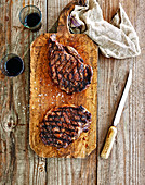 Grilled rump steaks on a wooden chopping board