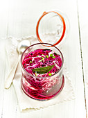Jar of thinly sliced white and red cabbage with seasoning for lacto-fermentation