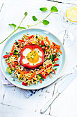 Noodles with vegetables and an egg cooked in half a red pepper