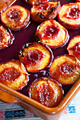 Oven-roasted plums garnished with redcurrant jelly