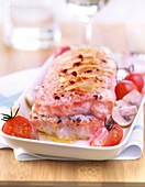 Salmon roast stuffed with cereal and almonds with cherry tomatoes and button mushrooms