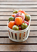 Assortment of stone-fruit in a wooden basket