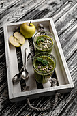 Delicious detox smoothie in glasses on rustic wooden tray