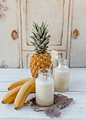 Organic fruit smoothie with bananas and pineapple on white background