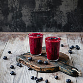 Fresh healthy berry smoothie in glasses on rustic table