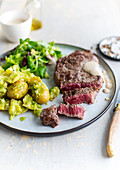 Beef steak served with potatoes and salsa verde