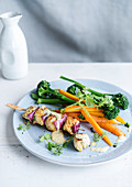 Chicken skewer with steamed carrots and broccoli