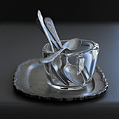 Teelöffel in Glasschälchen auf Silbertablett