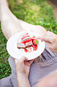 Woman eating a piece of strawberry cheesecake