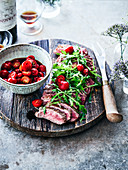 Grilled sliced beef fillet with rocket and cherry tomato salad