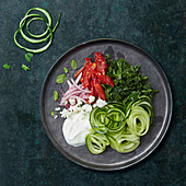 Cucumber spaghetti with kale, garlic cream, feta and tomato confit