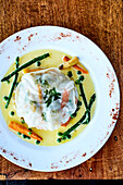 Giant ravioli made from rice leaves with vegetable filling and light butter sauce