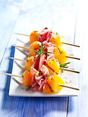 Mini skewers with melon, ham and rosemary