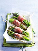 Bundles of green asparagus tied with strips of bacon