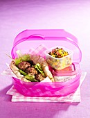 Meatball skewer in pita bread with salad in a lunch box to go