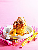 Baked apple garnished with Carambar candy and vanilla ice cream