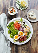Mixed salad with chicken, tomato, avocado, hard-boiled eggs and cheese
