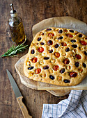 Fluffy focaccia with cherry tomatoes, black olives and feta