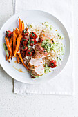 Turkey breast wrapped in bacon with rice, carrots, cherry tomatoes and pesto sauce