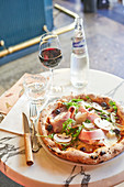 Pizza with cooked ham, mushrooms, rocket, olives and parmesan cheese