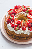 Ring-shaped birthday cake with cream and berries