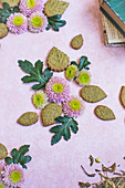 Matchakekse in Blätterform zusammen mit Blüten als Tischdekoration